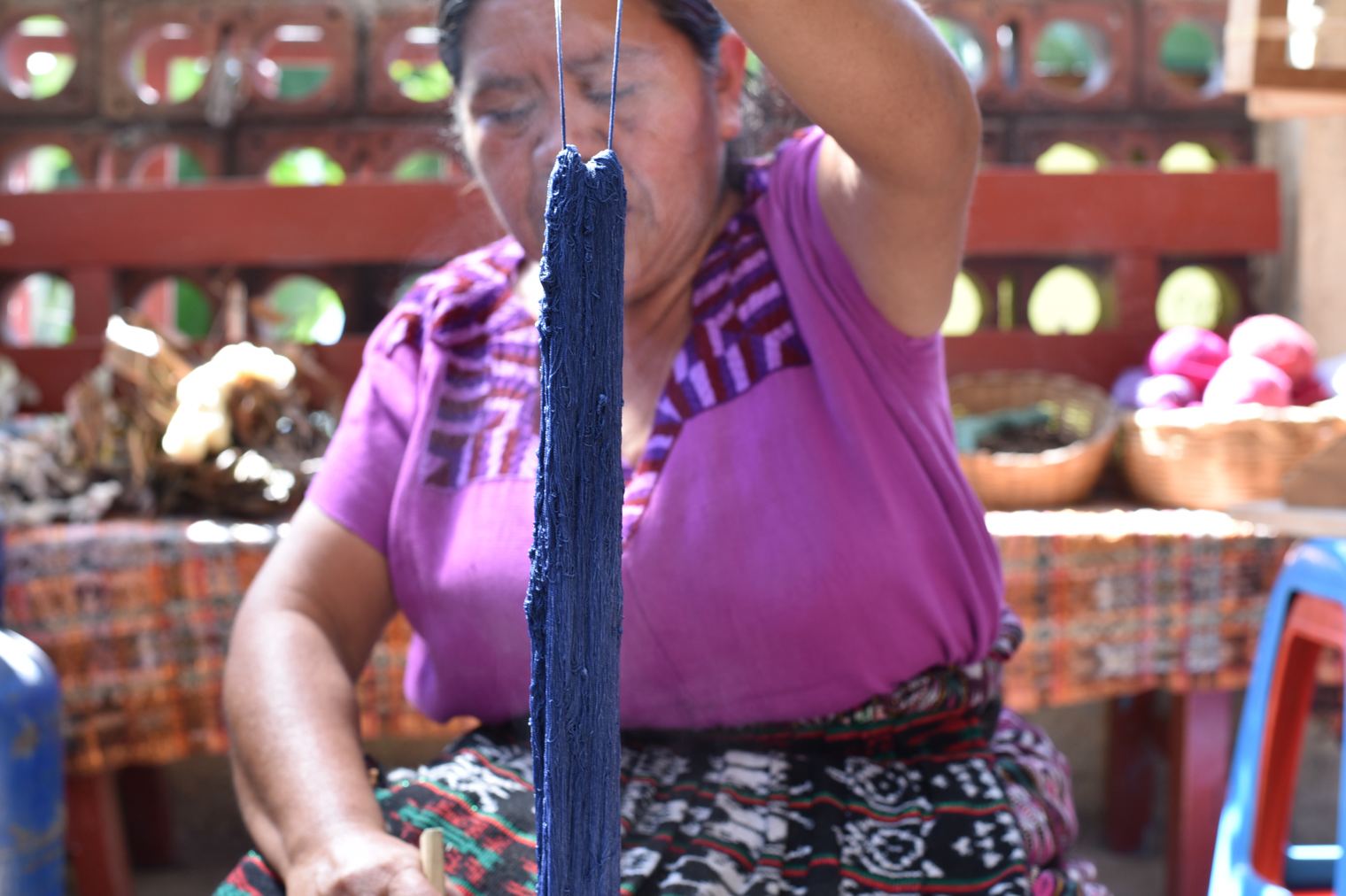 Guatemalan Craftswoman Rosario hand-botanically-dyeing cotton thread to be woven into fabric.